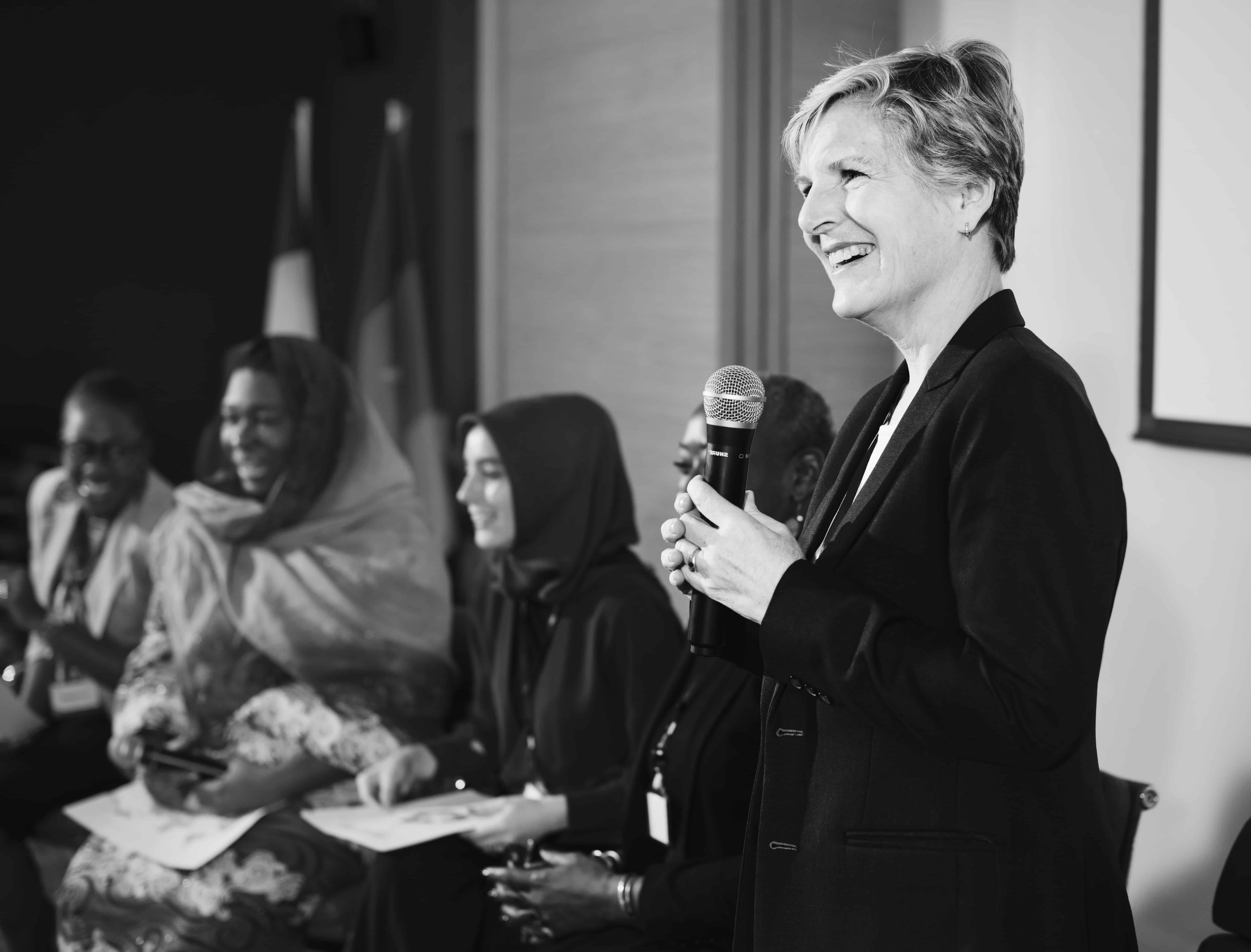 A Western Business Woman Speaking into a Microphone